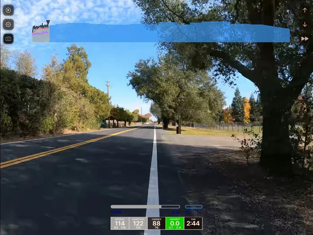 A straight rural road with double yellow lines stretches ahead under clear sky, bordered by autumn trees and fencing, with a dashcam display overlay at bottom.