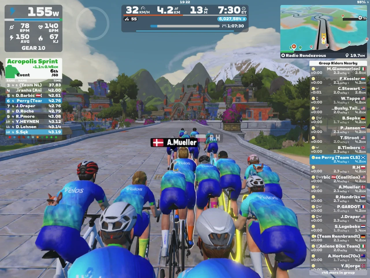 Riders avatars in sky blue kit riding towards green mountains on Zwift